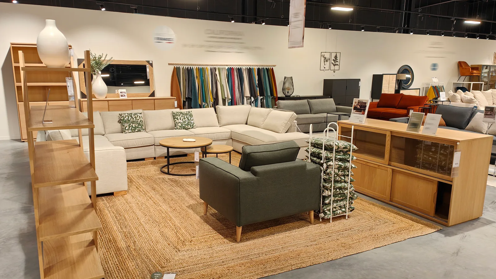 Espace de présentation d’un canapé modulable avec mobilier et accessoires coordonnés