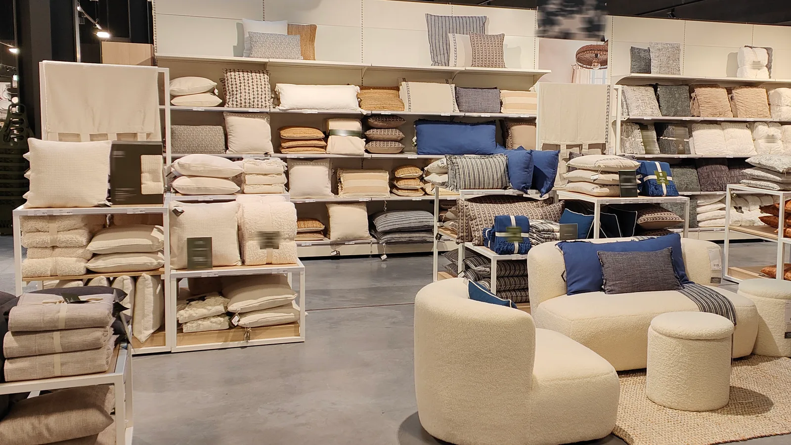 Coussins et plaids dans un rayon structuré par couleurs autour d’une assise