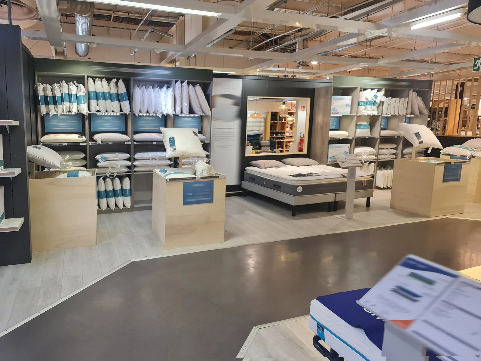 Rayon petite literie réorganisé avec oreillers, couettes et modules de présentation