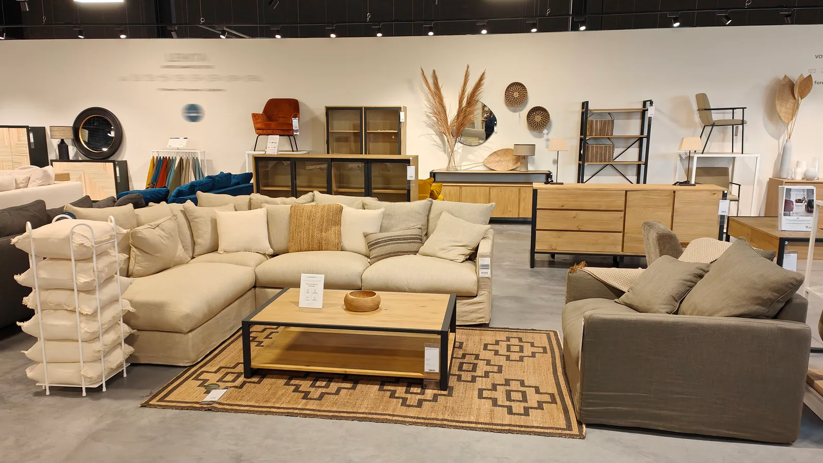 Canapés, tables, tapis et luminaires réunis dans une ambiance de salon en magasin